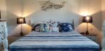 Guest bedroom has a king Bed with coastal decor